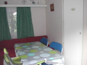 een kamer met een tafel en stoelen en een raam bij mobil home dordogne in Mouzens