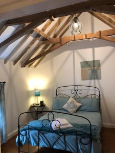 a bedroom with a bed in a room with beams at Church View Cottage, Ewerby in Sleaford