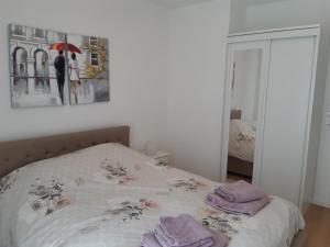- une chambre avec un lit et des serviettes pourpres dans l'établissement Le Carré des fleurs, à Strasbourg