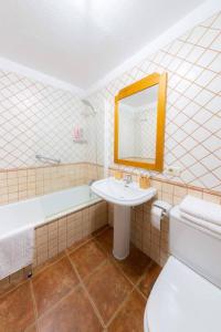 ein Badezimmer mit Waschbecken, Badewanne und Toilette in der Unterkunft Luminoso adosado frente al mar in El Médano