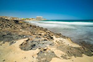 ein Blick auf den Strand mit einem Gebäude im Hintergrund in der Unterkunft Luminoso adosado frente al mar in El Médano