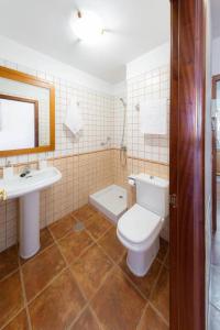 ein Badezimmer mit einer weißen Toilette und einem Waschbecken in der Unterkunft Luminoso adosado frente al mar in El Médano + 25 Fotos