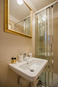 a bathroom with a white sink and a shower at Apartment City Center Amaryllis in Rovinj