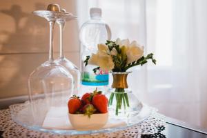 un piatto di vetro con fragole e fiori su un tavolo di Apartment City Center Amaryllis a Rovigno (Rovinj)