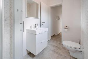 a white bathroom with a toilet and a sink at Apartment Fresh - Parking included in Izola