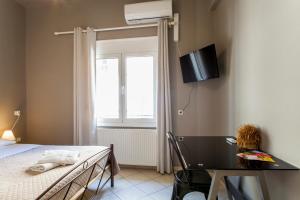 a bedroom with a bed and a desk and a television at So Young Hostel in Heraklio Town
