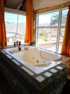 bañera grande en una habitación con ventanas en Cities of the World - Apartments Cusco, en Cusco