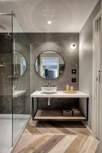 ein Bad mit einem Waschbecken und einem Spiegel in der Unterkunft Italianflat - Design rooms Verona in Verona