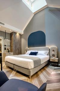 Schlafzimmer mit einem großen Bett mit blauem Kopfteil in der Unterkunft Italianflat - Design rooms Verona in Verona