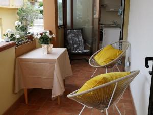 a kitchen with a table and chairs with a yellow pillow at Elisabeth's house in Iglesias