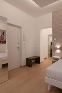 a white bedroom with a bed and a table at S B&B (Pescara Centro) in Pescara
