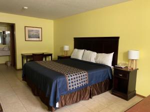 a bedroom with a large bed with a blue blanket at Riverwood Inn in Glenwood
