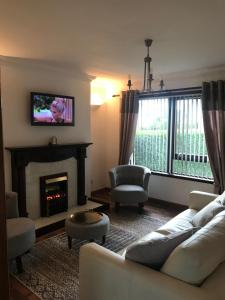 een woonkamer met een bank en een open haard bij Hebridean Holiday House in Stornoway