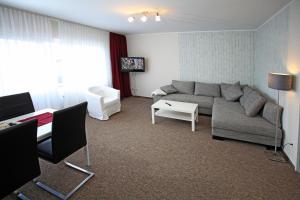 a living room with a couch and a table at Appartementanlage Vierjahreszeiten in Braunlage