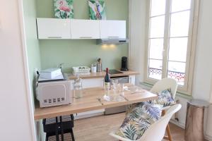 a kitchen with a table with chairs and a microwave at La jungle - Vue directe et magnifique sur le port- in Saint-Valery-en-Caux