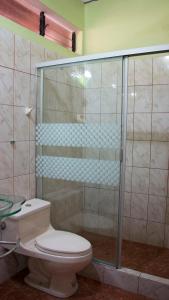 a bathroom with a toilet and a glass shower at Hotel Rio Huallaga in Yurimaguas