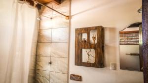 uma casa de banho com um chuveiro, um espelho e um lavatório. em Vibra Guesthouse Popoyo em Popoyo