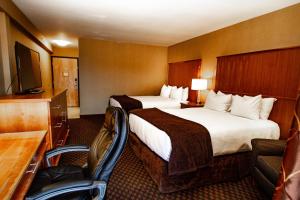 a hotel room with two beds and a flat screen tv at Mirabeau Park Hotel in Spokane Valley