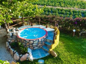 una piscina en un patio con una pared de piedra en Villa Marqua, en Kalavárda