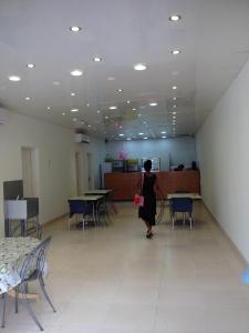 uma mulher a andar por uma sala com mesas e cadeiras em HotelMidnight78 em Paramaribo