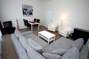 a living room with a couch and chairs and a table at Appartementanlage Vierjahreszeiten in Braunlage