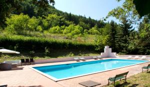 a swimming pool in a yard with chairs around it at Villa Gioia Civita in Fabriano