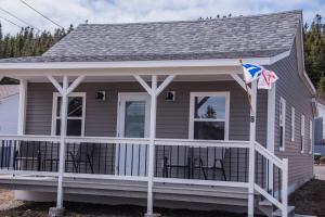 a house with a porch with chairs on it at Family Ties Vacation Home - Greenham House in Twillingate