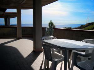 einen Tisch und Stühle auf einer Terrasse mit Meerblick in der Unterkunft Oasi di pace a pochi passi dal mare, vista fantastica sul mare, Wi-Fi Gratuito, parcheggio in Santa Caterina Dello Ionio Marina