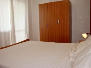Schlafzimmer mit einem Bett und einem Holzschrank in der Unterkunft Oasi di pace a pochi passi dal mare, vista fantastica sul mare, Wi-Fi Gratuito, parcheggio in Santa Caterina Dello Ionio Marina