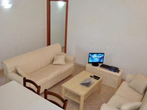 a living room with a couch and a table with a tv at Alba Splendente in Santa Caterina Dello Ionio Marina