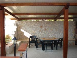 eine Terrasse mit einem Tisch, Stühlen und einer Steinmauer in der Unterkunft Oasi di pace a pochi passi dal mare, vista fantastica sul mare, Wi-Fi Gratuito, parcheggio in Santa Caterina Dello Ionio Marina