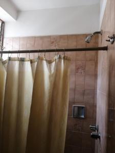 a shower with a shower curtain in a bathroom at Hotel Lider in Caracas