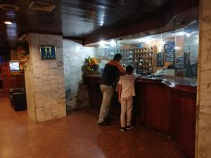 a man and a young boy standing at a bar at Hotel Lider in Caracas