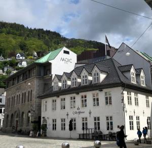 un gran edificio blanco con un cartel. en Magic Hotel Korskirken en Bergen