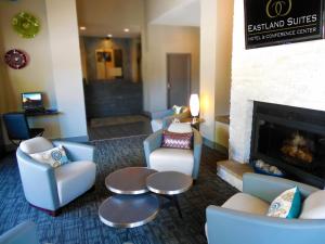 a lobby with chairs and a fireplace in a hotel at Eastland Suites Hotel & Conference Center in Bloomington
