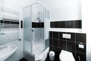 uma casa de banho com um chuveiro, um WC e um lavatório. em Hotel Elegia am Kurfürstendamm em Berlim