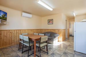 - une salle à manger avec une table, des chaises et un canapé dans l'établissement Hamilton Caravan Park, à Hamilton