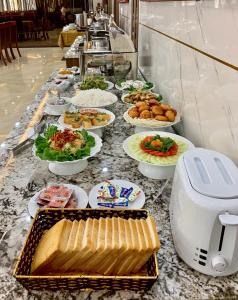 a buffet with plates of food on a table at Emma Hotel in Ha Long