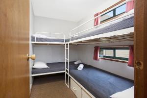 two bunk beds in a small room with a door at Hamilton Caravan Park in Hamilton