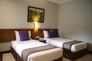 Postelja oz. postelje v sobi nastanitve Cakra Kembang Hotel