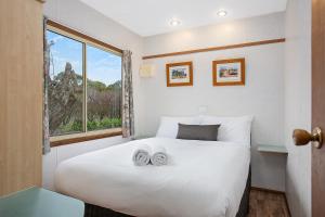 
A bed or beds in a room at Lake Hamilton Motor Village and Caravan Park

