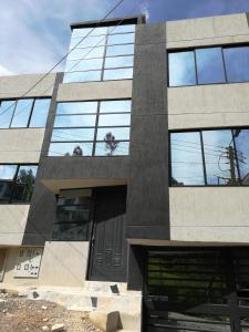 un edificio con ventanas de cristal y una puerta en Apartamentos Paipa, en Paipa