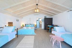a living room with two beds and a table at GLAROS BUNGALOW in Skala Kallirachis