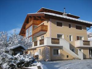 un gran edificio de apartamentos con nieve en el suelo en Apartments Etruska, en Santa Cristina Valgardena