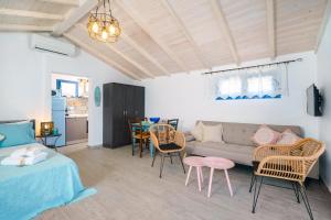 a living room with a couch and chairs and a table at GLAROS BUNGALOW in Skala Kallirachis