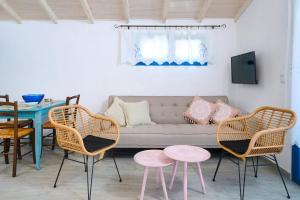 a living room with a couch and chairs and a table at GLAROS BUNGALOW in Skala Kallirachis