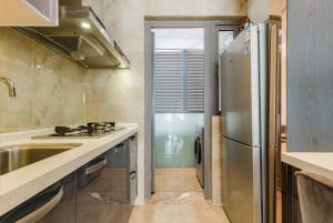 a kitchen with a stainless steel refrigerator and a sink at Tianfu IN Service Apartement in Chengdu