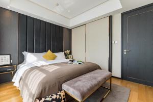 a bedroom with a large bed and a black wall at Tianfu IN Service Apartement in Chengdu