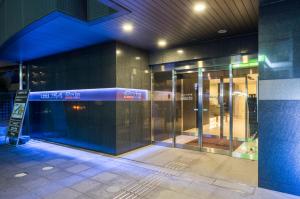 an entrance to a building with revolving doors at Dormy Inn Express Mikawaanjo in Anjomachi