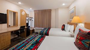 a hotel room with two beds and a desk at Inn at Santa Fe, SureStay Collection by Best Western in Santa Fe +18 photos